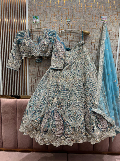 Fantástico top corto color azul cielo con diseño de pavo real y falda Lehenga.